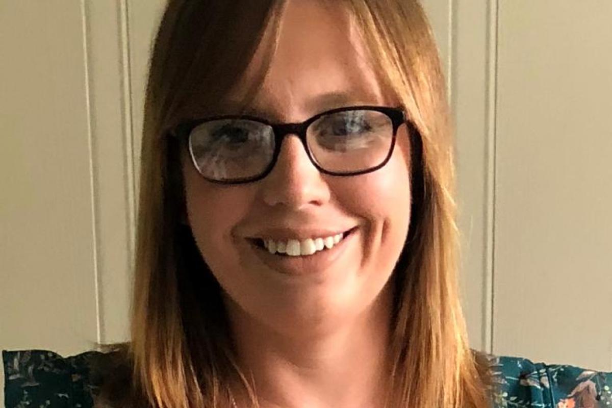 Chrisi smiling with a blouse and glasses